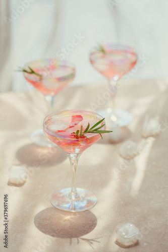 Glass of strawberry soda drink on light beige background. Summer healthy detox lemonade, cocktail or another drink background. Nonalcoholic drinks, super food, vegetarian or healthy diet concept.