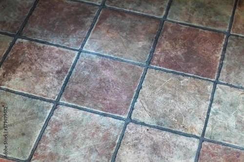 Old, dirty ceramic floor tiles. Close-up.