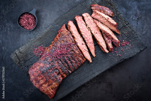 Barbecue wagyu bavette beef steak with red wine salt offered as top view on charred wooden black board