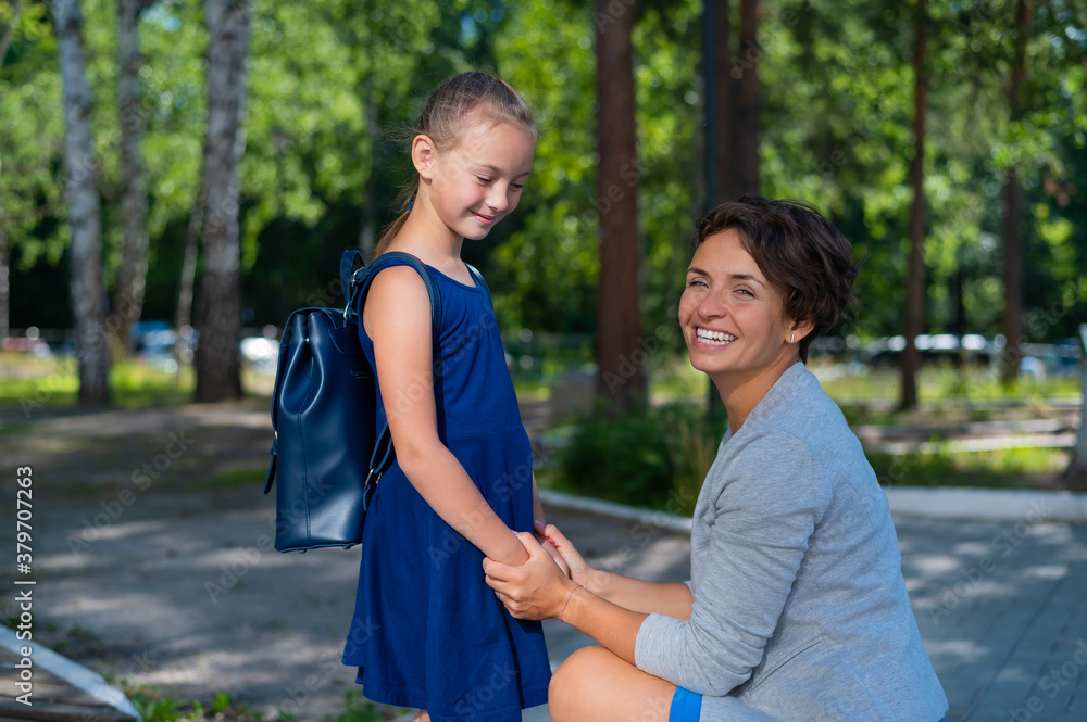 Caucasian woman gathers her first-grader daughter to school Caucasian woman gathers her first-grader daughter to school
