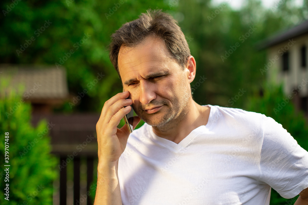 Close up view of confident handsome man talking on mobile phone outdoors. Businessman making phone call, calling on smartphone. Copy space, summer, communication, people, digital gadgets concept Close up view of confident handsome man talking on mobile phone outdoors. Businessman making phone call, calling on smartphone. Copy space, summer, communication, people, digital gadgets concept