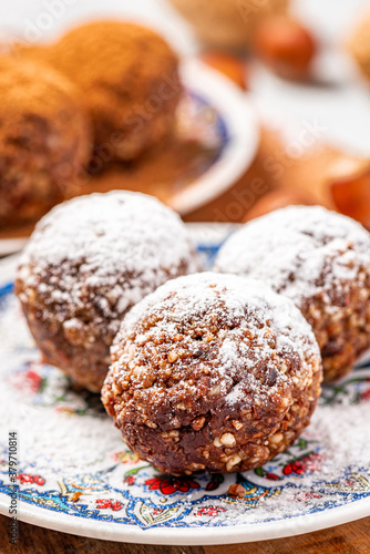 Healthy homemade paleo chocolate energy balls with nuts, dates and cocoa close-up. Homemade chocolate round candies. Sweet food with nuts.