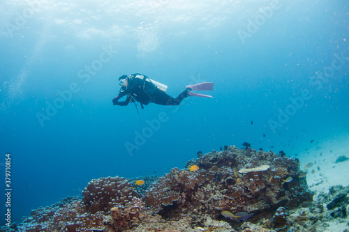 Female scuba diver swimming under water.
