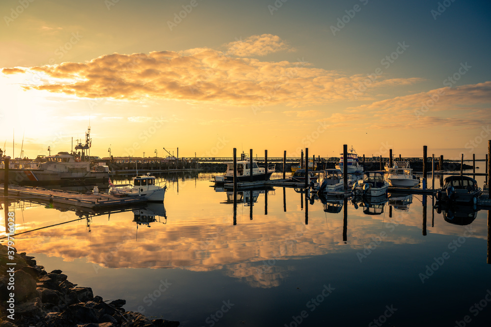 Beautiful sunset with clouds over marina with boats in Bandon, Oregon