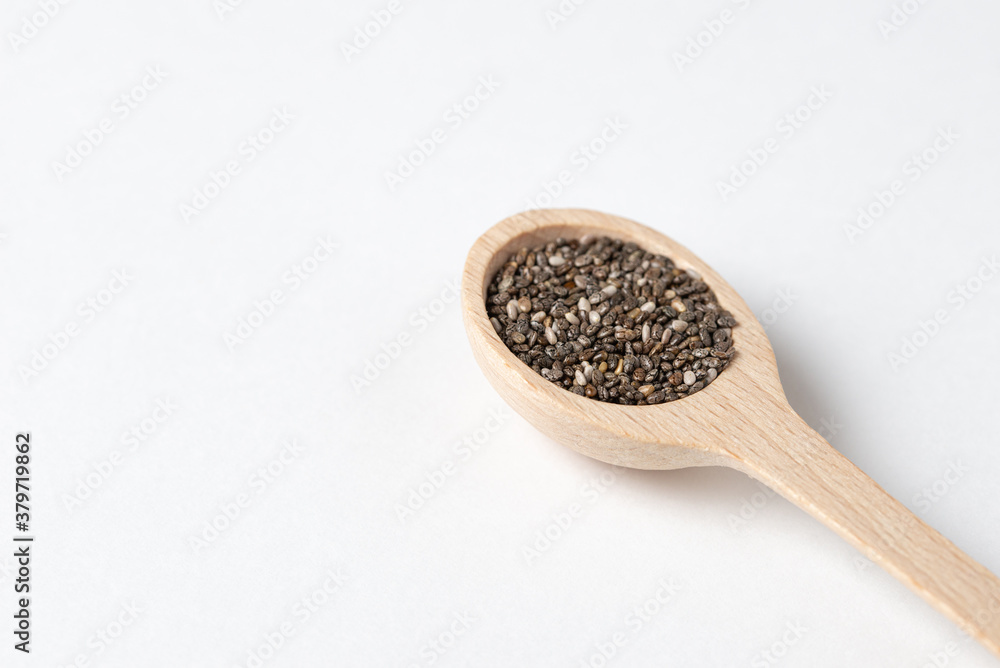Superfood concept with chia seeds in wooden spoon on white background. Superfood concept with chia seeds in wooden spoon on white background.