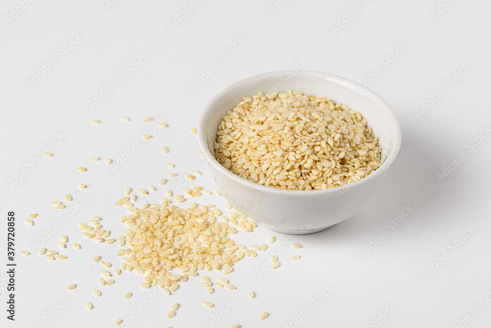 Raw sesame seeds in ceramic bowl on white background for Superfood and diet product concept, close up Raw sesame seeds in ceramic bowl on white background for Superfood and diet product concept, close up