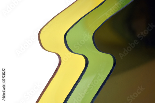 Abstract plastic background in yellow, green and brown colors. Close-up photo of plastic lenses for sunglasses