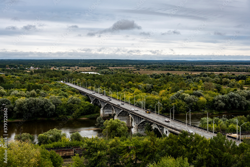 road across the river against the background of a green forest from the observation deck