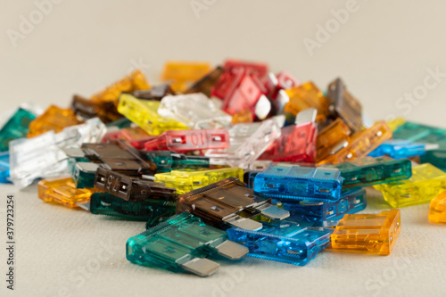 Car fuse. Fold colorful electric car fuses or circuit breakers isolated on beige background.