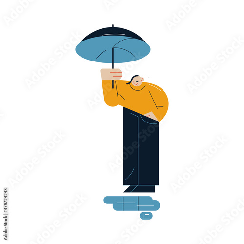 Sad man standing with umbrella and looking at puddles during rain