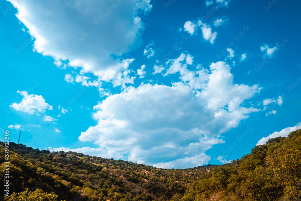 Blue sky with clouds over the mountain with green forest on a sunny day. Blue sky with clouds over the mountain with green forest on a sunny day.