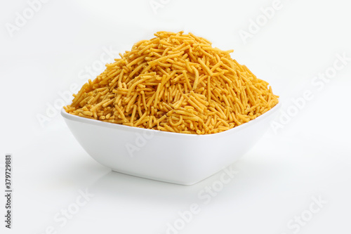 Indian snacks aloo bhujiaa in white bowl in white background.
