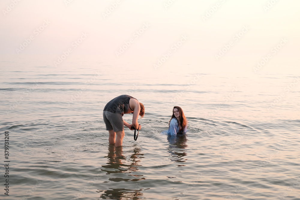 a girl is photographed by a photographer in sea water