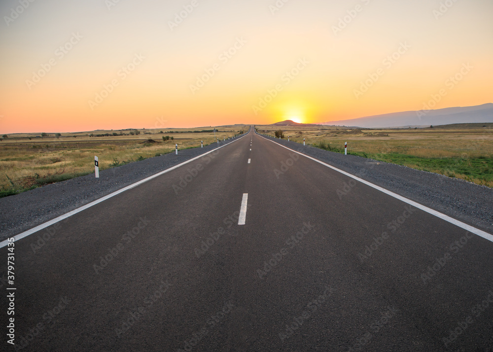 asphalt road with sunset