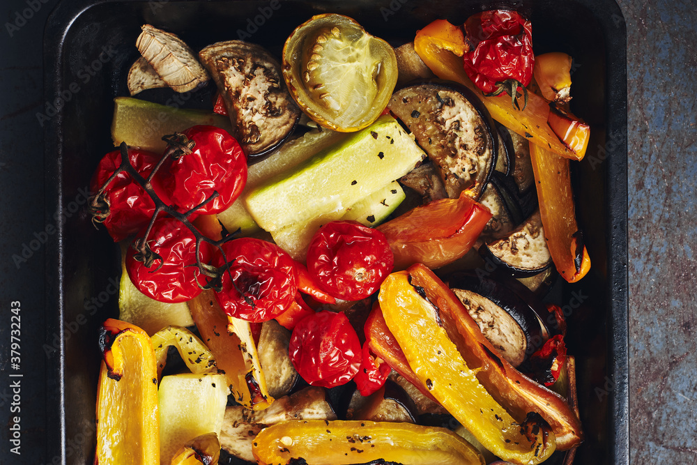 Roasted sliced vegetables on a baking tray.