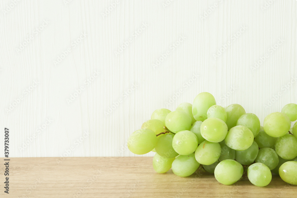 Bunch of green grapes on the wooden background with space for text Bunch of green grapes on the wooden background with space for text