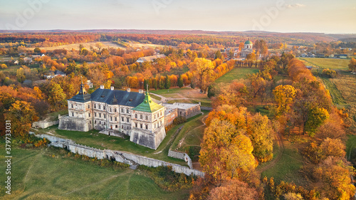 Sunset over autumn park on hills. Aerial view of Pidhirtsi Castle, Ukraine