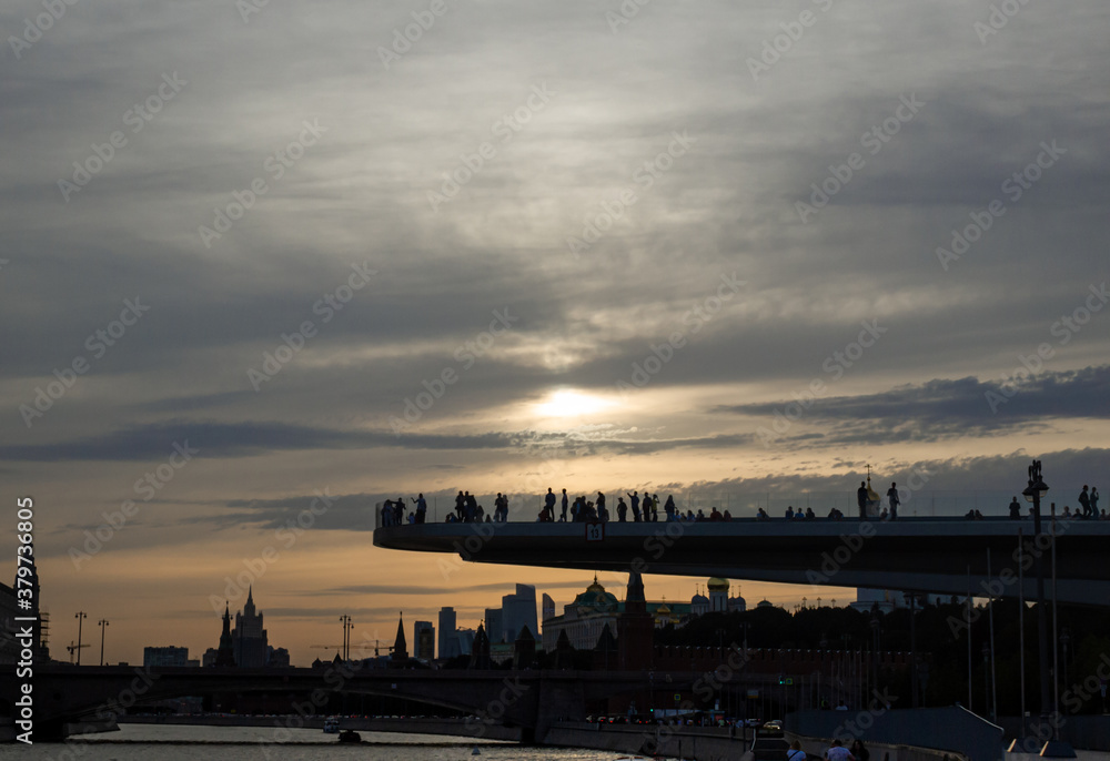 Flying bridge on the cityscape background: sunset hour