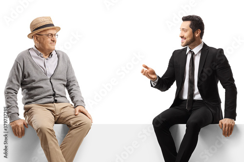Elderly gentleman and a businessman sitting on a panel and talking