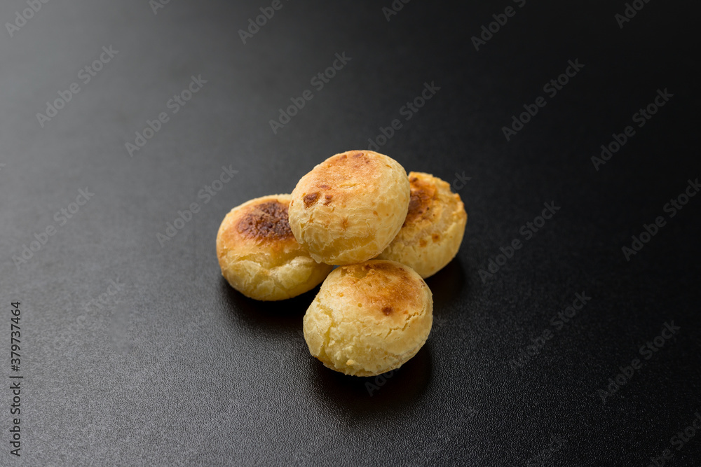 Traditional Brazilian Snack Cheese Bread. On a black table background Traditional Brazilian Snack Cheese Bread. On a black table background