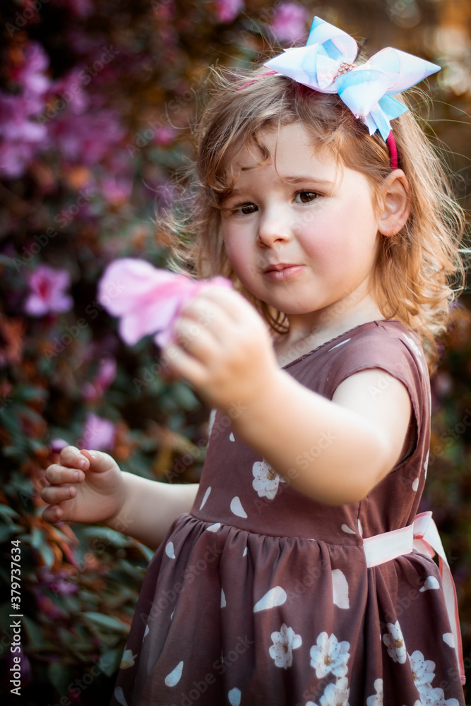 Menina loira, criança pequena, brincando em meio a um jardim de ...