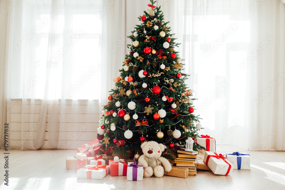 Christmas tree with gifts of garland lights for the new year in the interior of the white room as a backdrop Christmas tree with gifts of garland lights for the new year in the interior of the white room as a backdrop