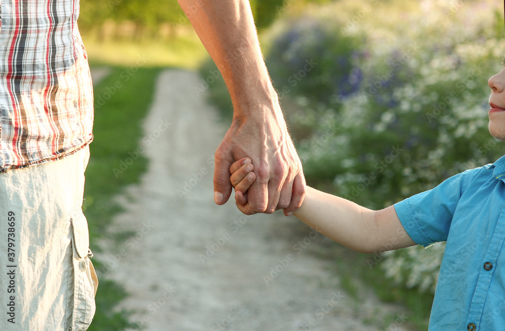 parent holds the hand of a small child parent holds the hand of a small child