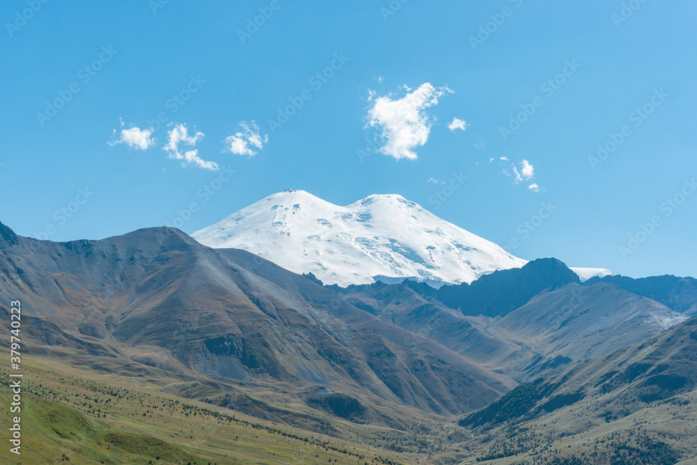 Scenic view of the highest peak in Europe, mount Elbrus with green hills on a Sunny summer day. Scenic view of the highest peak in Europe, mount Elbrus with green hills on a Sunny summer day.