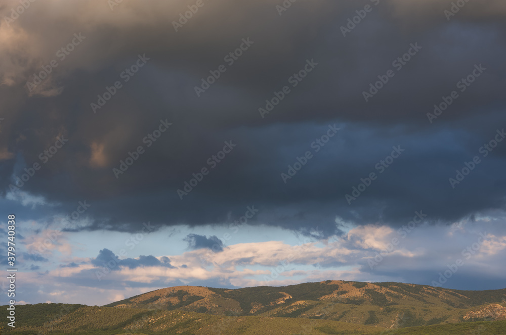 Gray storm clouds over the mountain. Autumn landscape before the rain. Dark blue terrible storm clouds. Bajdarsky valley. Crimea. Gray storm clouds over the mountain. Autumn landscape before the rain. Dark blue terrible storm clouds. Bajdarsky valley. Crimea.