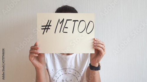 Young woman holding sign with metoo hashtag text. Sexual abuse, equal gender right.  photo