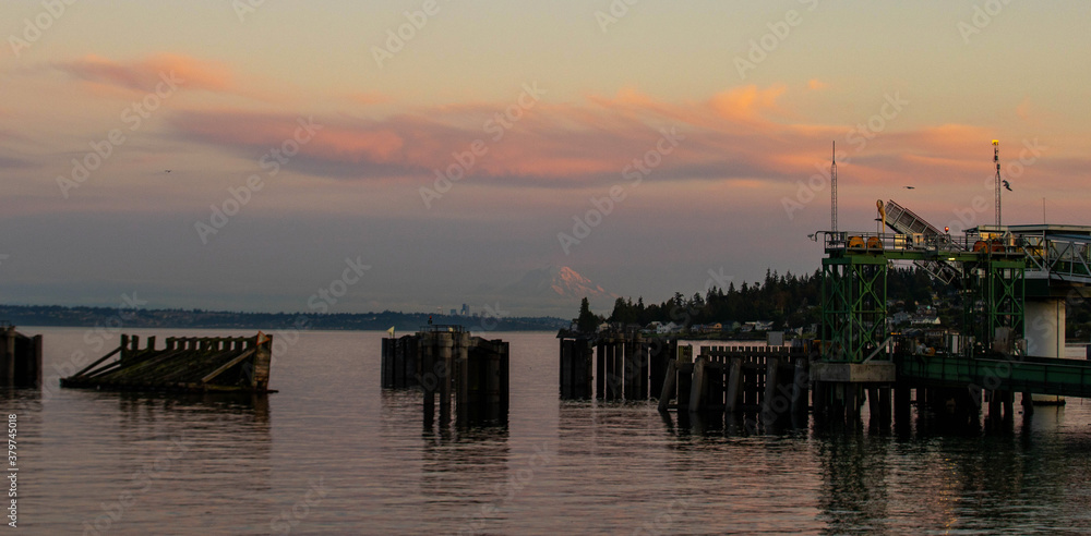 Obraz premium General view of Kingston, Washington ferry dock over the Puget Sound with Mount Rainier under the sunset with a pink and orange colorful sky