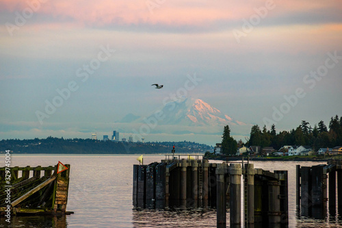 General view of Kingston, Washington ferry dock over the Puget Sound with Mount Rainier under the sunset with a pink and orange colorful sky
