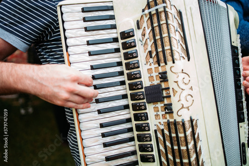 Close-up of male hand playing on accordion. Traditional instruments