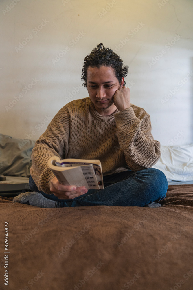 Young man reading a book at home Young man reading a book at home