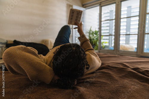 Young man reading a book at home photo