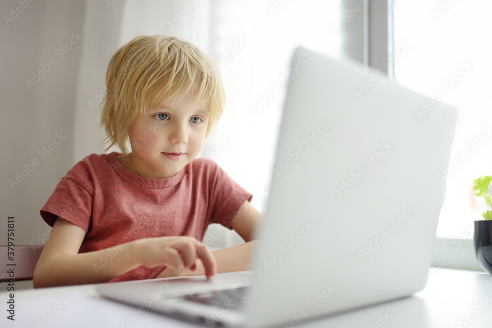 Schoolboy use the computer app for study using laptop in the home. Child and gadgets. Online education and distance learning for kids. Schoolboy use the computer app for study using laptop in the home. Child and gadgets. Online education and distance learning for kids.