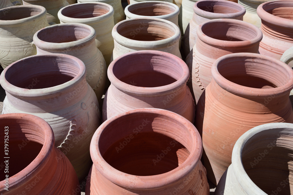 Large clay jugs stand in the market and are photographed from above
