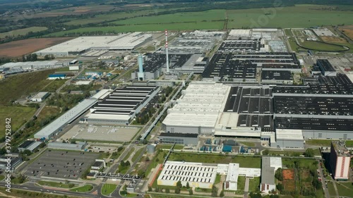 Contemporary factory with car parking. Industrial complex among green fields. Huge area of manufacturing near the road in countryside. Aerial view. bratislava.