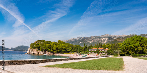Picturesque panorama of Milocer Plaza the king's luxurious beach in Przno village, Montenegro. Tiny beach with massive moutnains in the background. photo