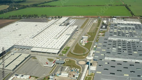 Contemporary factory with car parking. Industrial complex among green fields. Huge area of manufacturing near the road in countryside. Aerial view. bratislava.