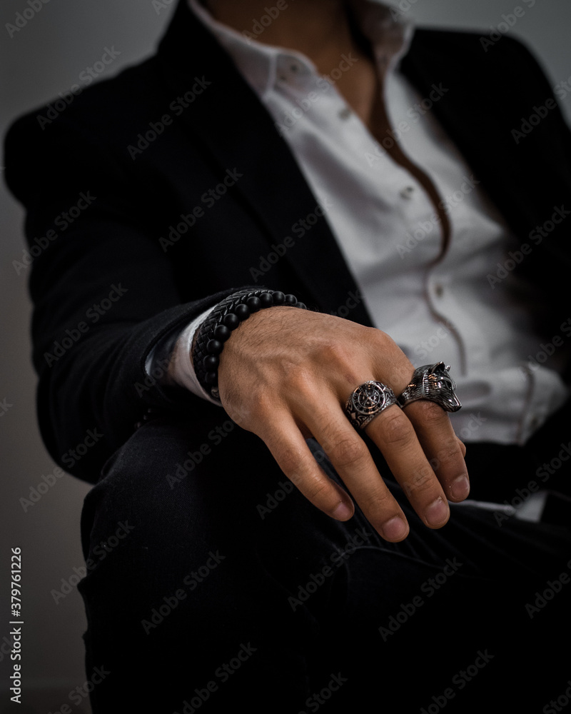 hands of a businessman wearing rings and bracelets