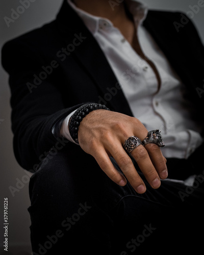 hands of a businessman wearing rings and bracelets