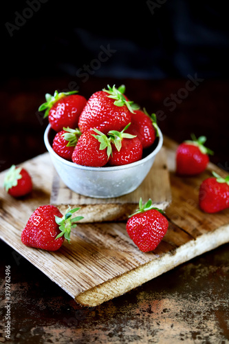 Fresh juicy strawberries in a bowl. Selective focus. Macro.