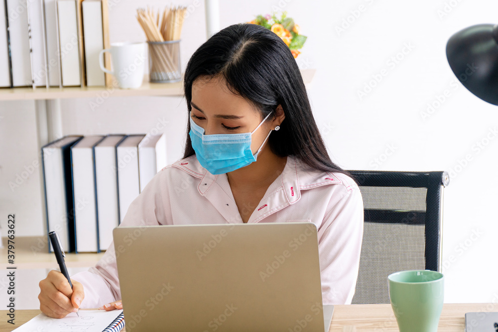 Freelance young woman wears masks protect against airborne disease and during outbreak of covid 19 while working with laptop from home. Society distance prevent the spread of corona virus concept. Freelance young woman wears masks protect against airborne disease and during outbreak of covid 19 while working with laptop from home. Society distance prevent the spread of corona virus concept.