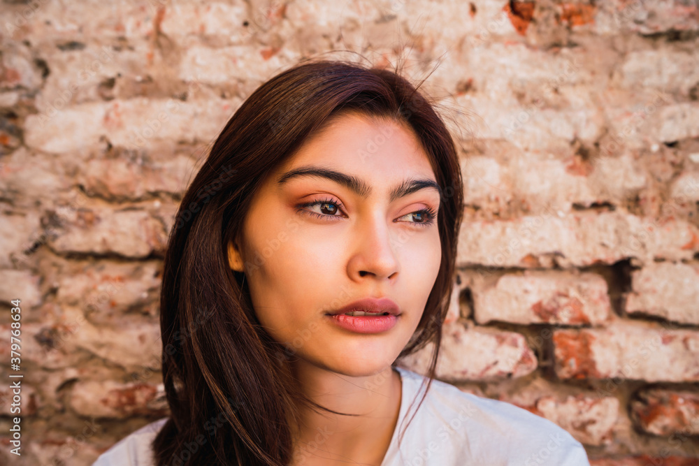 Young latin woman against brick wall. Young latin woman against brick wall.