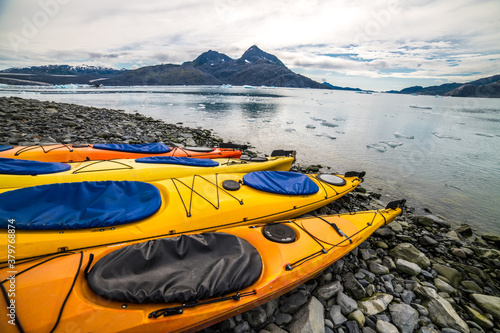 Double kayaks parked on the bay on scenic mountain ocean bay during arctic expedition