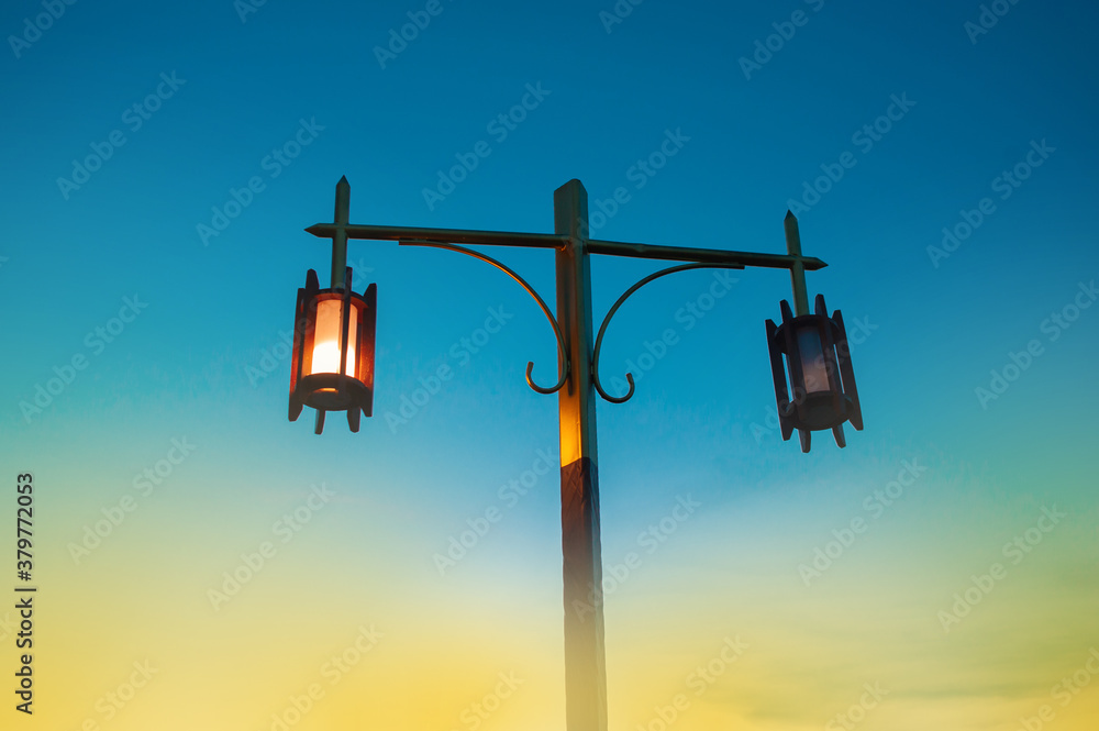 Old and vintage lamps on the pillars. It is shining in the evening