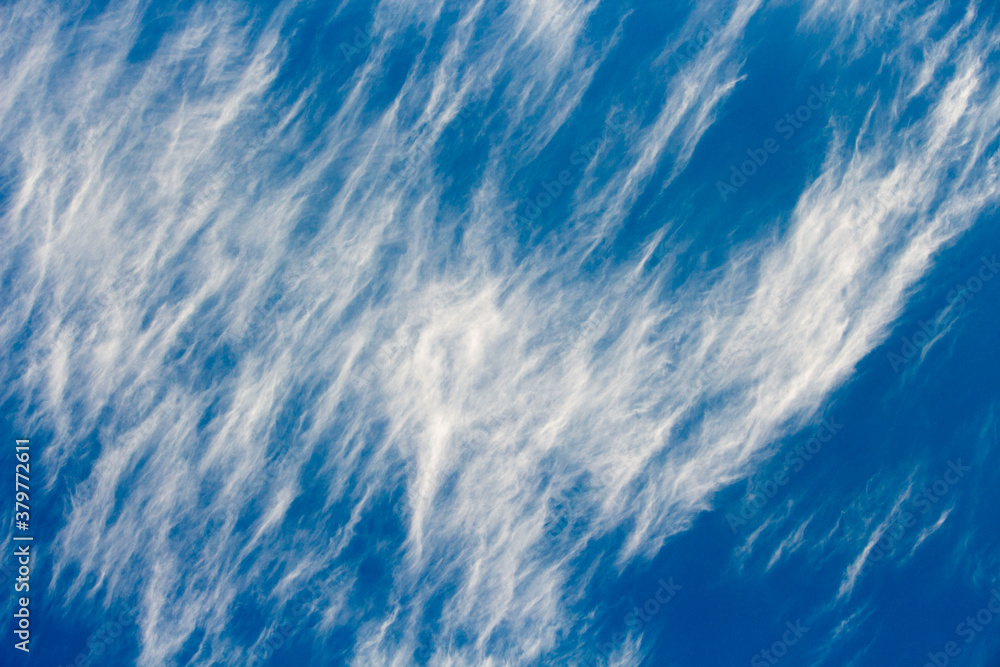 High white wispy cirrus clouds with cirrostratus in the blue