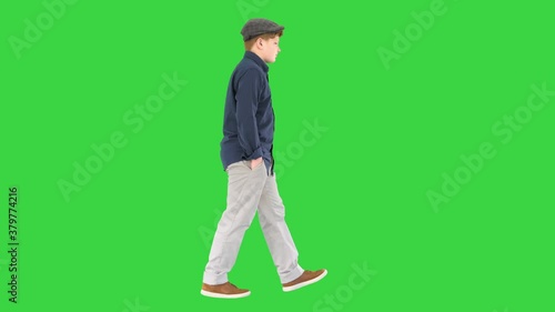 Stylish teenage boy in a shirt and a cap walking on a Green Screen, Chroma Key. photo