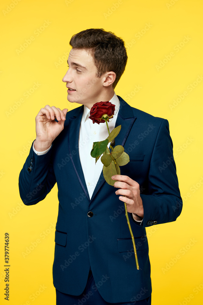 Gentlemen in classic suit on yellow background and red rose romance cropped view model portrait.